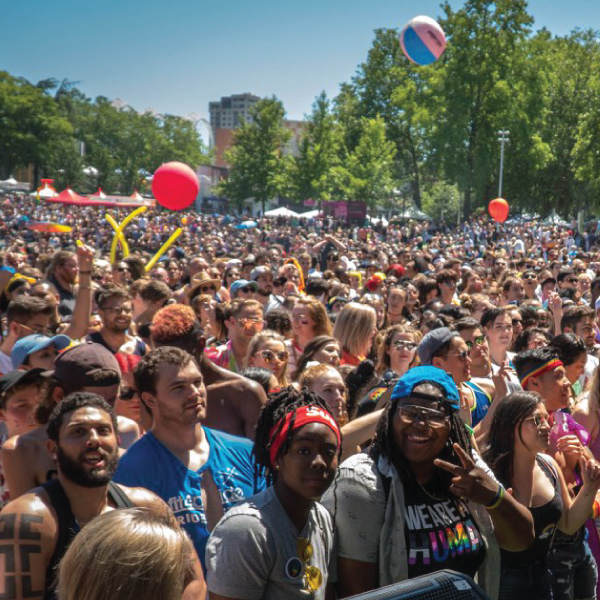Large crowd of diverse people celebrating outdoors.