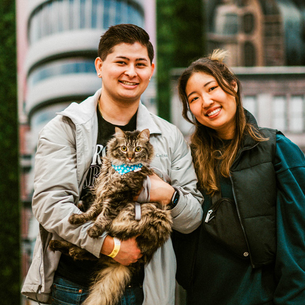 Happy couple holding their cat.