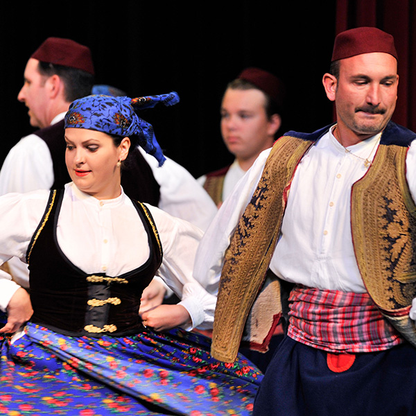 Dancers in colorful clothing spinning with hands on their hips.