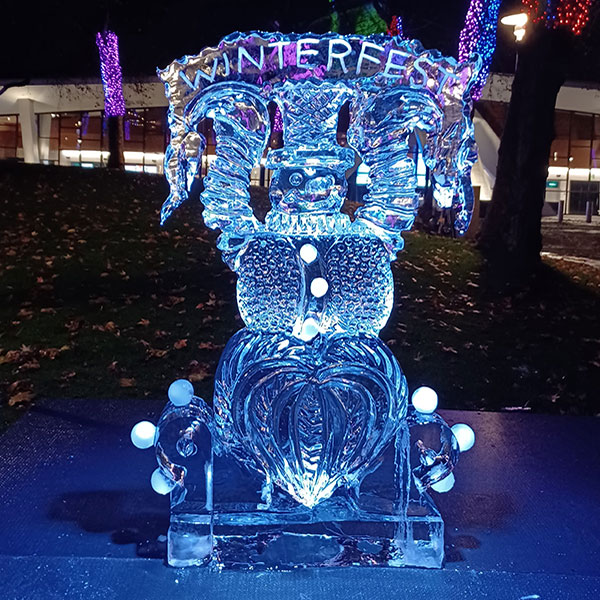 ice sculpture says Winterfest and is bathed in blue light