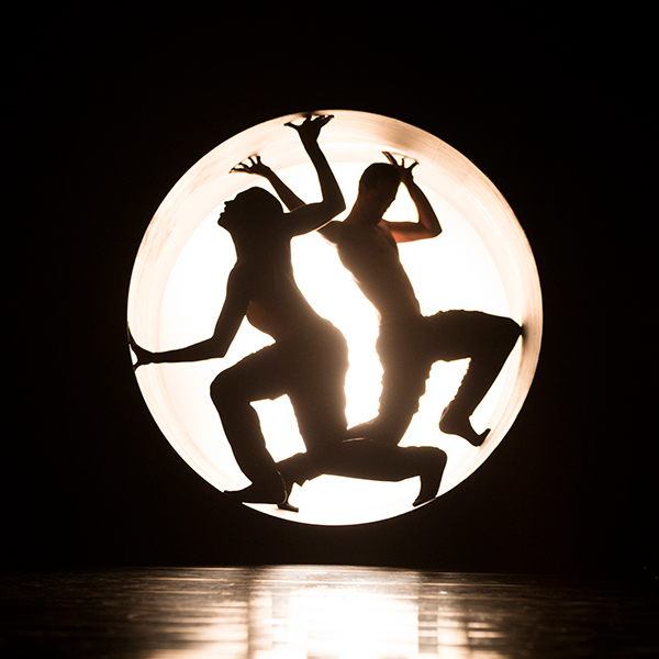 Two silhouettes of people trapped in a circular light